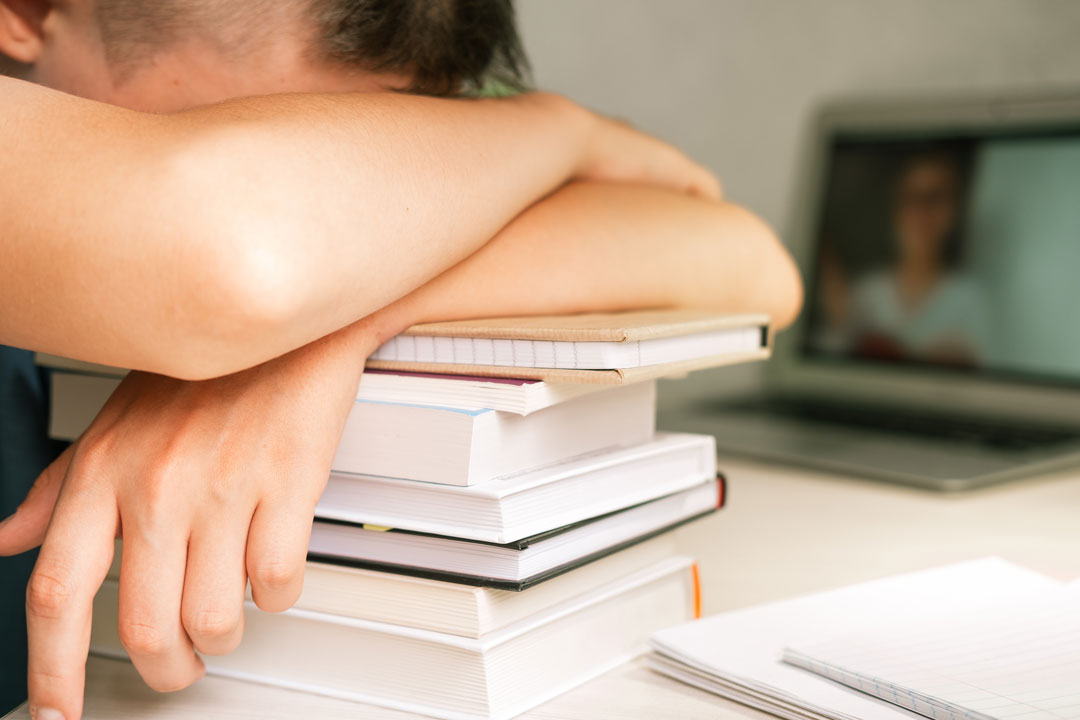 Ragazzo annoiato sui libri: perché i ragazzi non vogliono studiare?